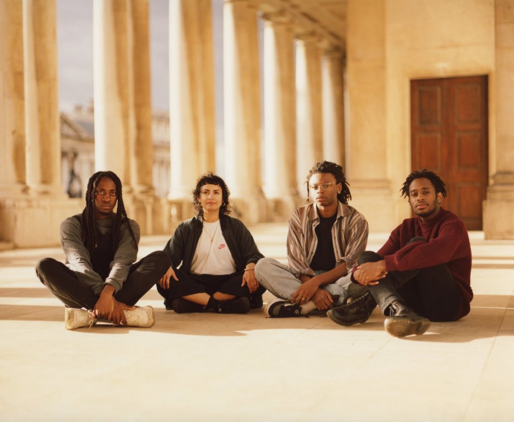 All 4 members of Whitelands sitting in front of columns looking at camera